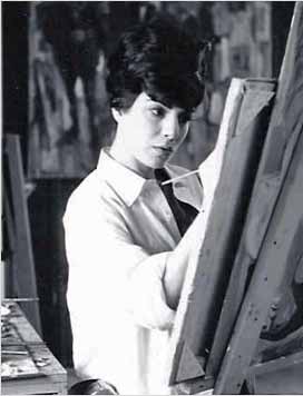 A young man is painting in an art studio.