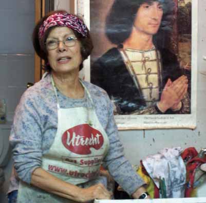 A woman standing in front of a painting.