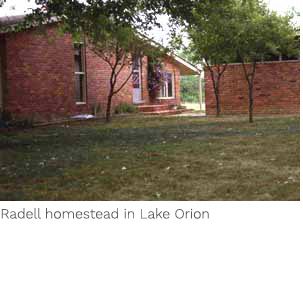 A brick house with trees in the background.